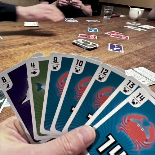 A hand of seven cards, five of which are crabs.